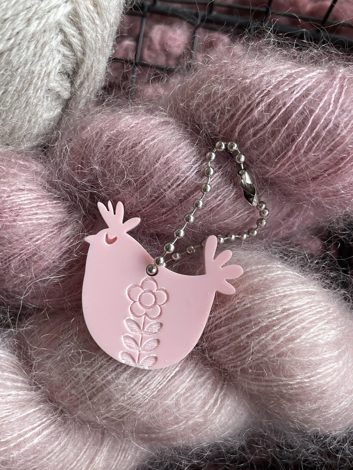 Soft pink yarn ball with fluffy texture on a craft workspace.