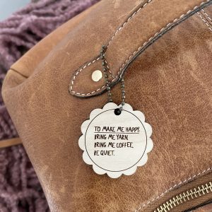 Soft brown leather bag with a yarn-themed inspirational tag, perfect for knitting and crochet enthusiasts.