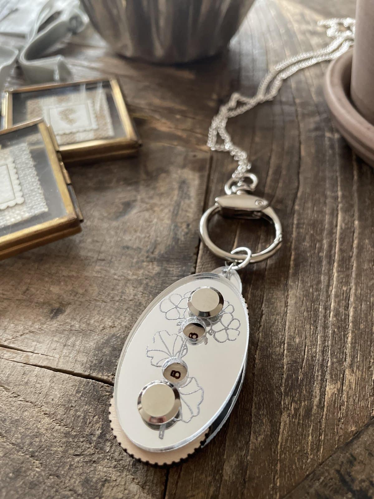 Shimmering keychain with floral design, perfect for accessorizing or gifting. Elegant, silver-tone with decorative elements.