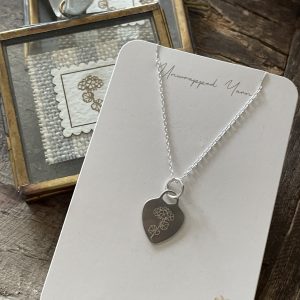 Delicate silver necklace with engraved hydrangea flower pendant, perfect for handmade jewelry lovers.