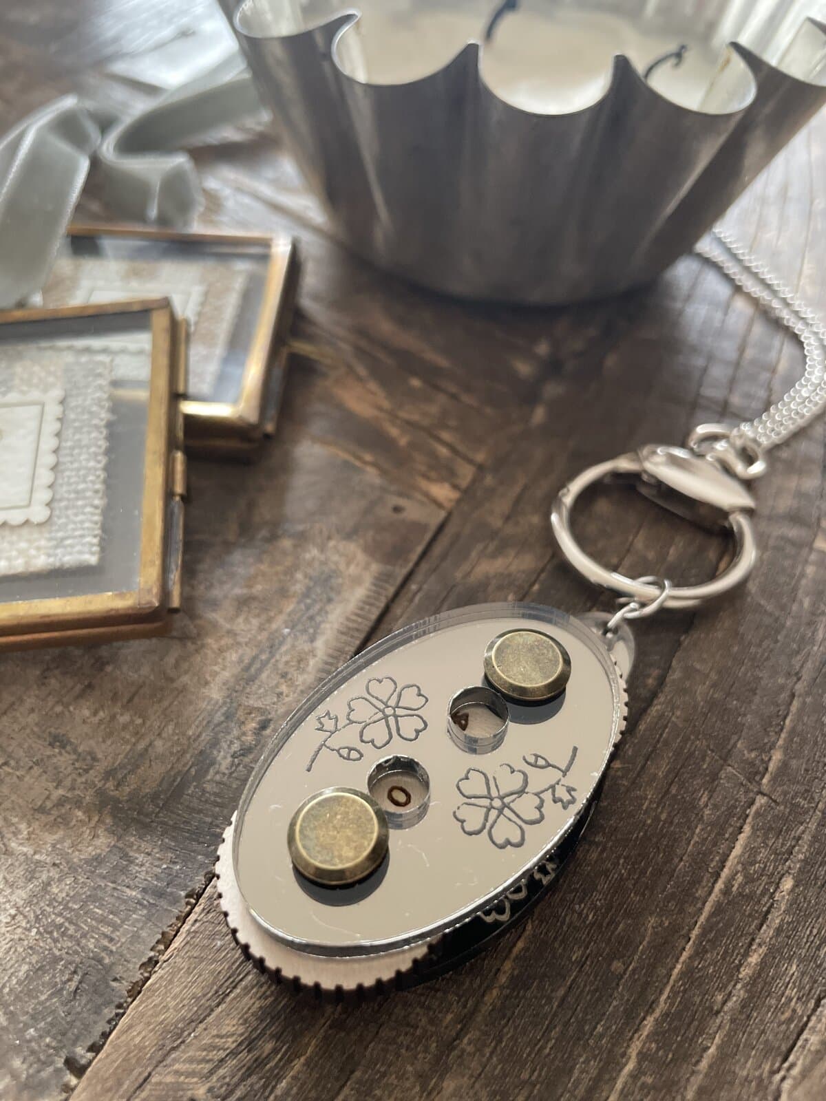 1. Silver keychain with shamrock design and magnets on wooden surface.