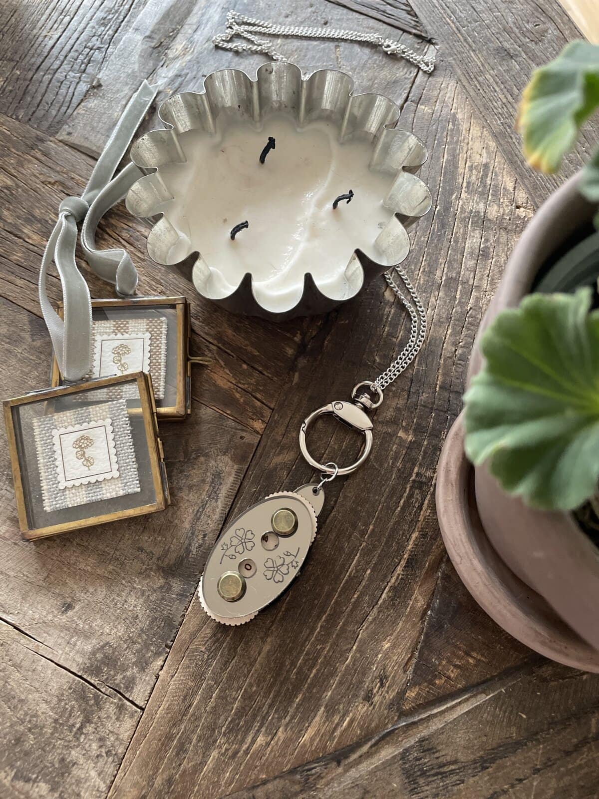 Elegant silver jewelry and decorative candles on rustic wooden surface.