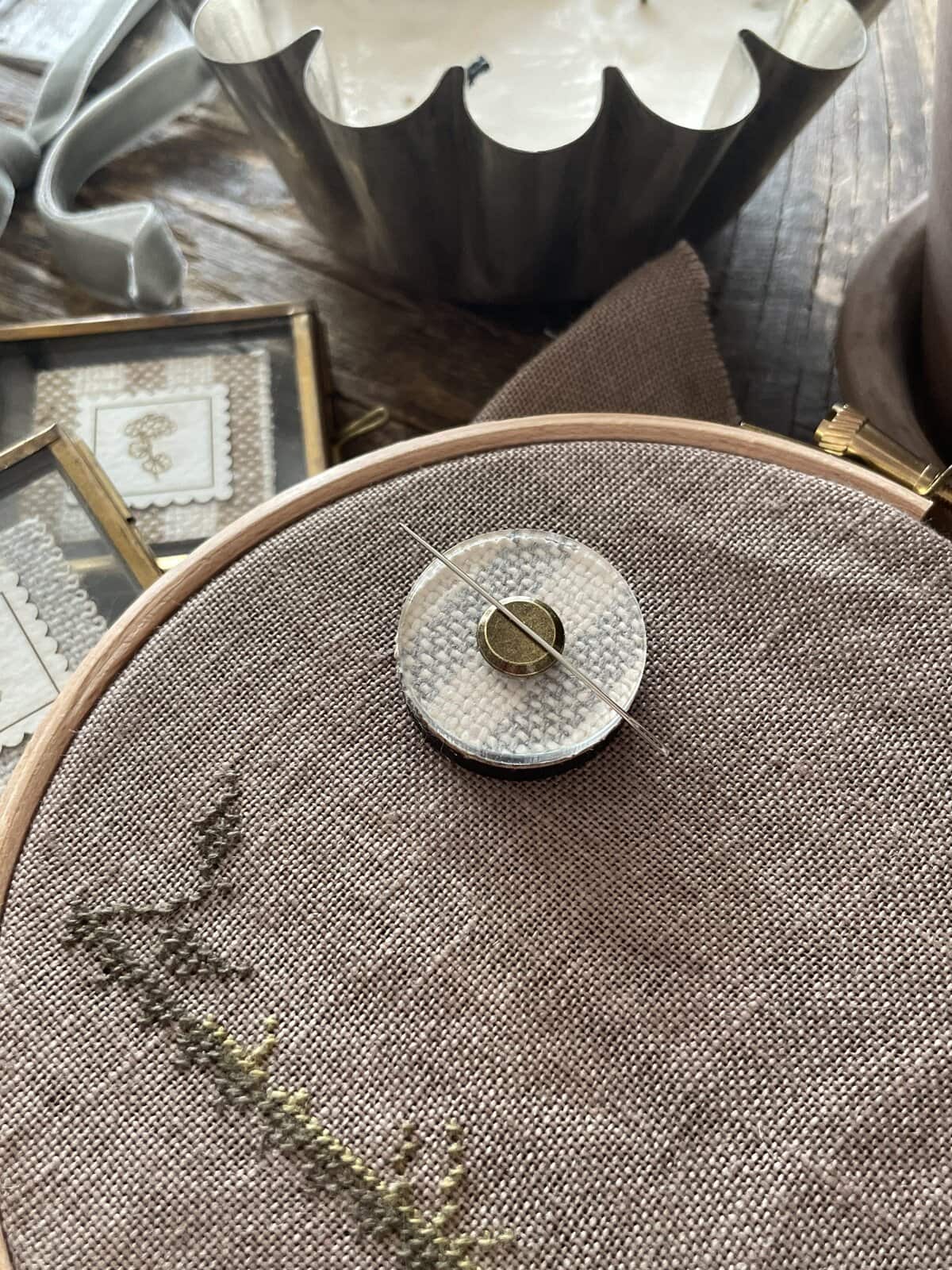 Soft beige embroidery floss on linen fabric, perfect for handmade fiber art projects.