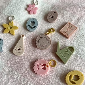 Colorful yarn cutting tools and accessories for knitting and crochet projects on soft fabric.