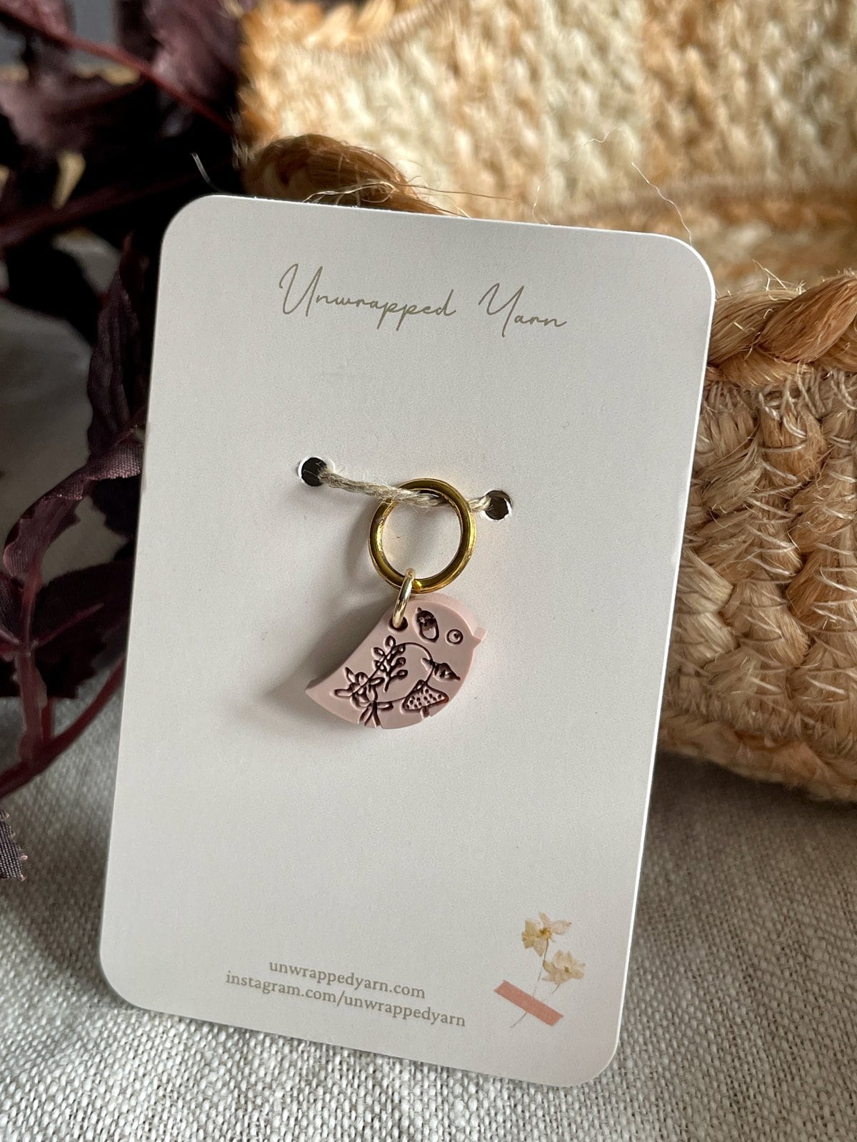 Delicate pink resin charm with floral and bird design, attached to a gold keyring for jewelry or accessories.