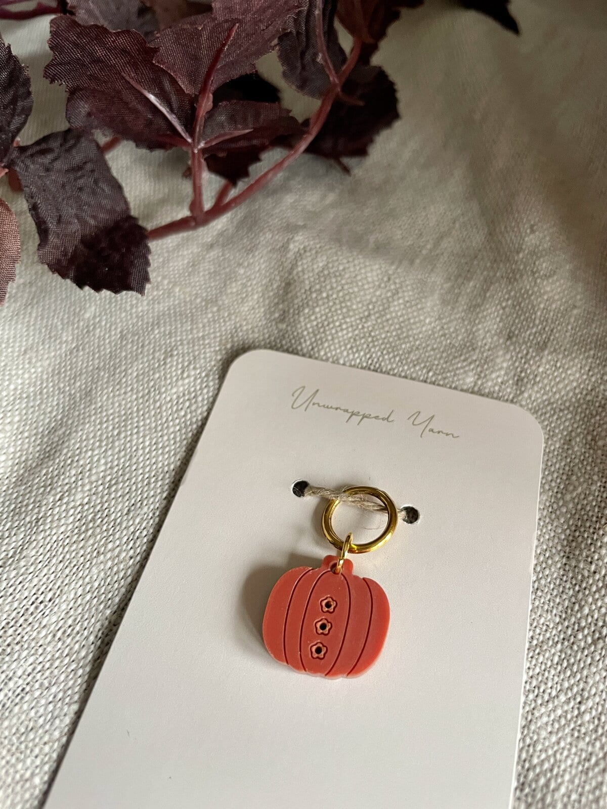 Sweet pumpkin charm accessory on stylish jewelry piece, perfect for fall-themed craft projects and jewelry design.