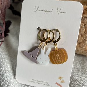 Cute yarn-inspired jewelry charms on gold rings, perfect for knitting and crafting enthusiasts.