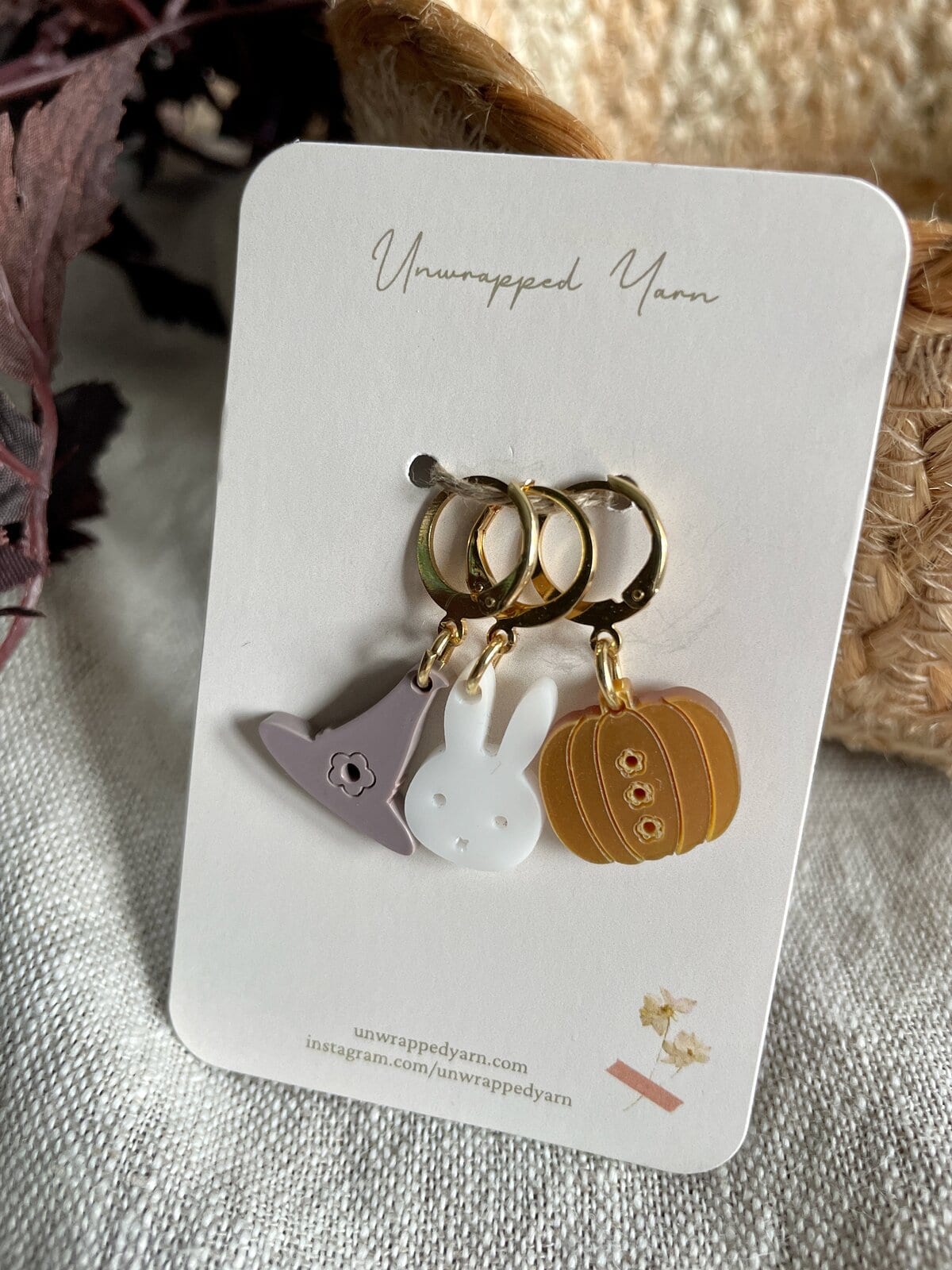Cute yarn-inspired jewelry charms on gold rings, perfect for knitting and crafting enthusiasts.