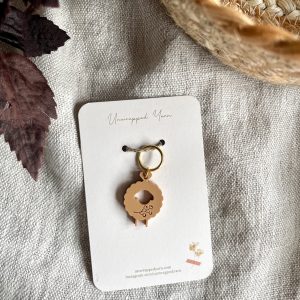Delicate crochet sheep keychain with gold accents, handmade from eco-friendly materials.