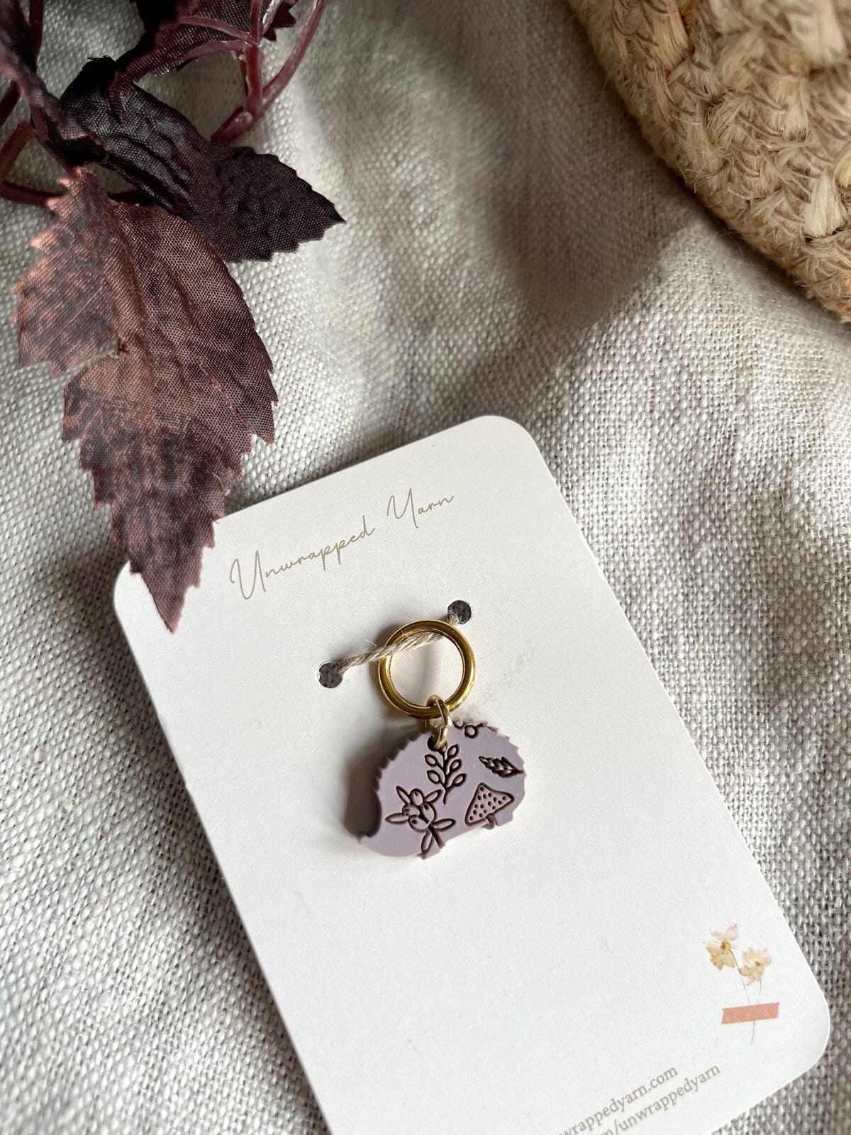 Soft pink resin keychain with floral and mushroom design, on a white card from Unwrapped Yarn.