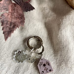 Chic silver keychain with floral, ladybug, camera, and house charms for jewelry and accessories.