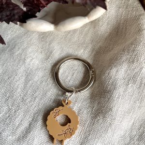 Colorful yarn art keychain on a silver ring with a sheep and floral design, perfect for craft enthusiasts and decorations.