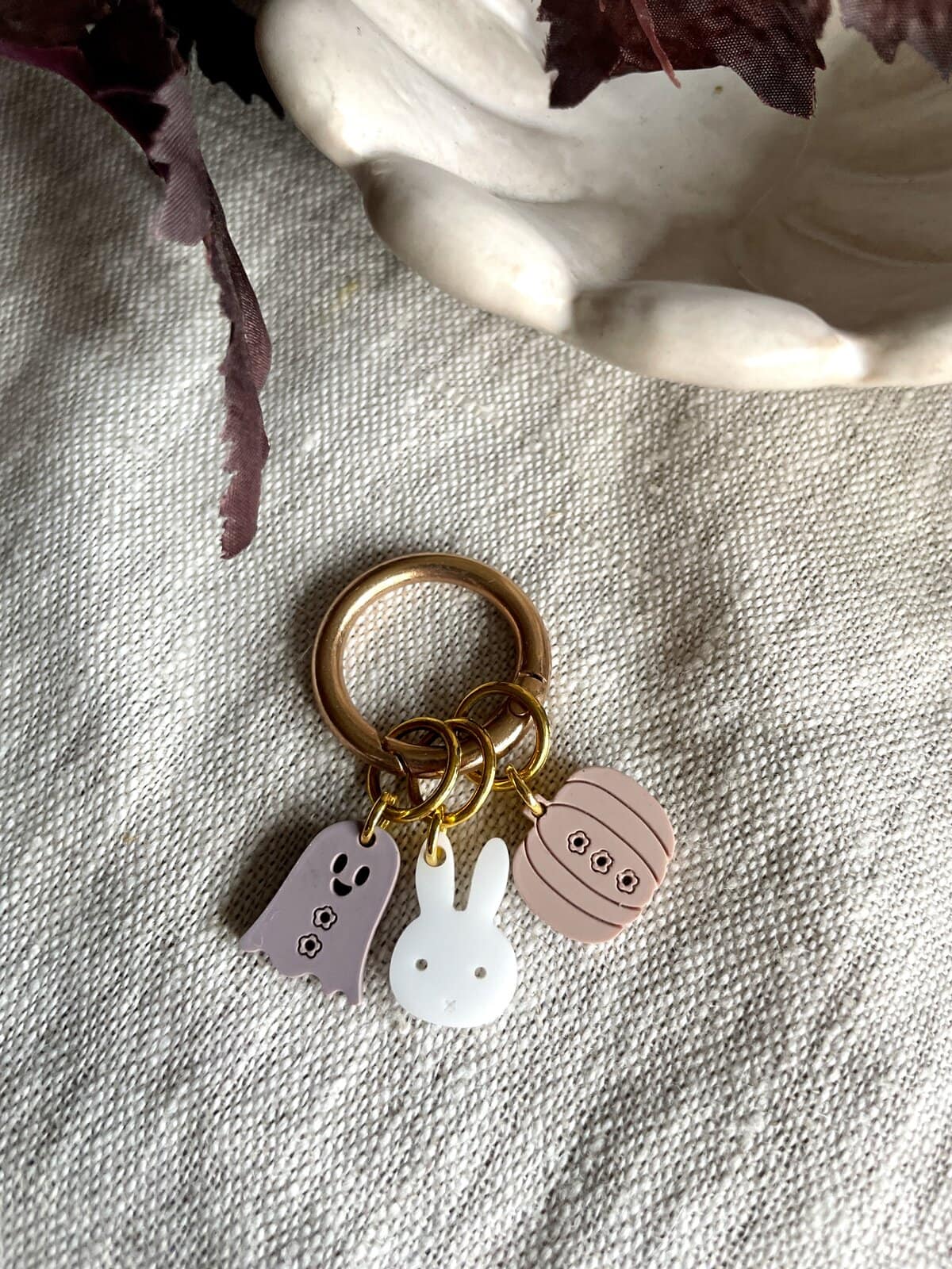Cute bunny and ghost silicone keychain charms on a gold keyring, perfect for accessorizing bags or keys.