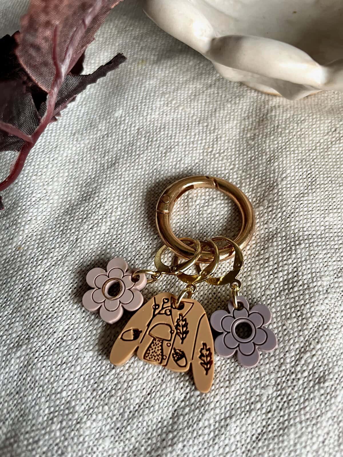 Colorful floral and mushroom keychains on gold rings, perfect for accessories and gift ideas.