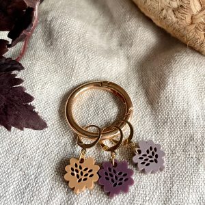 Colorful flower-shaped acrylic keychains on gold rings, stylish accessories for bags or keys.
