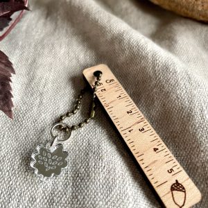 Rustic metal ball chain with leaf-shaped charm on neutral fabric background. Perfect for jewelry and craft projects.