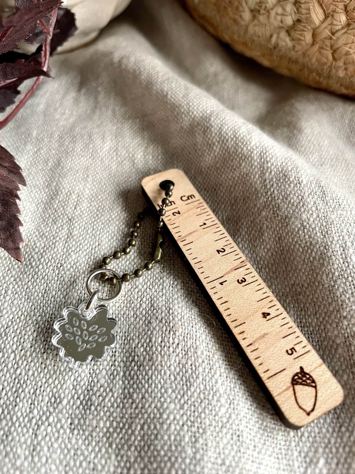 Rustic metal ball chain with leaf-shaped charm on neutral fabric background. Perfect for jewelry and craft projects.