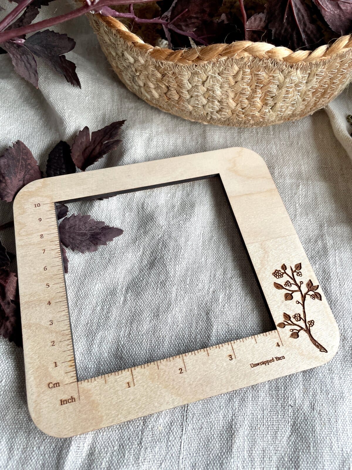 Softwood measuring frame with engraved floral design, ideal for yarn and knitting projects.
