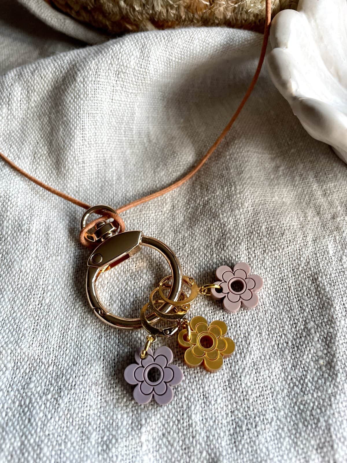 Colorful jewelry charms with flower design on metal rings.
