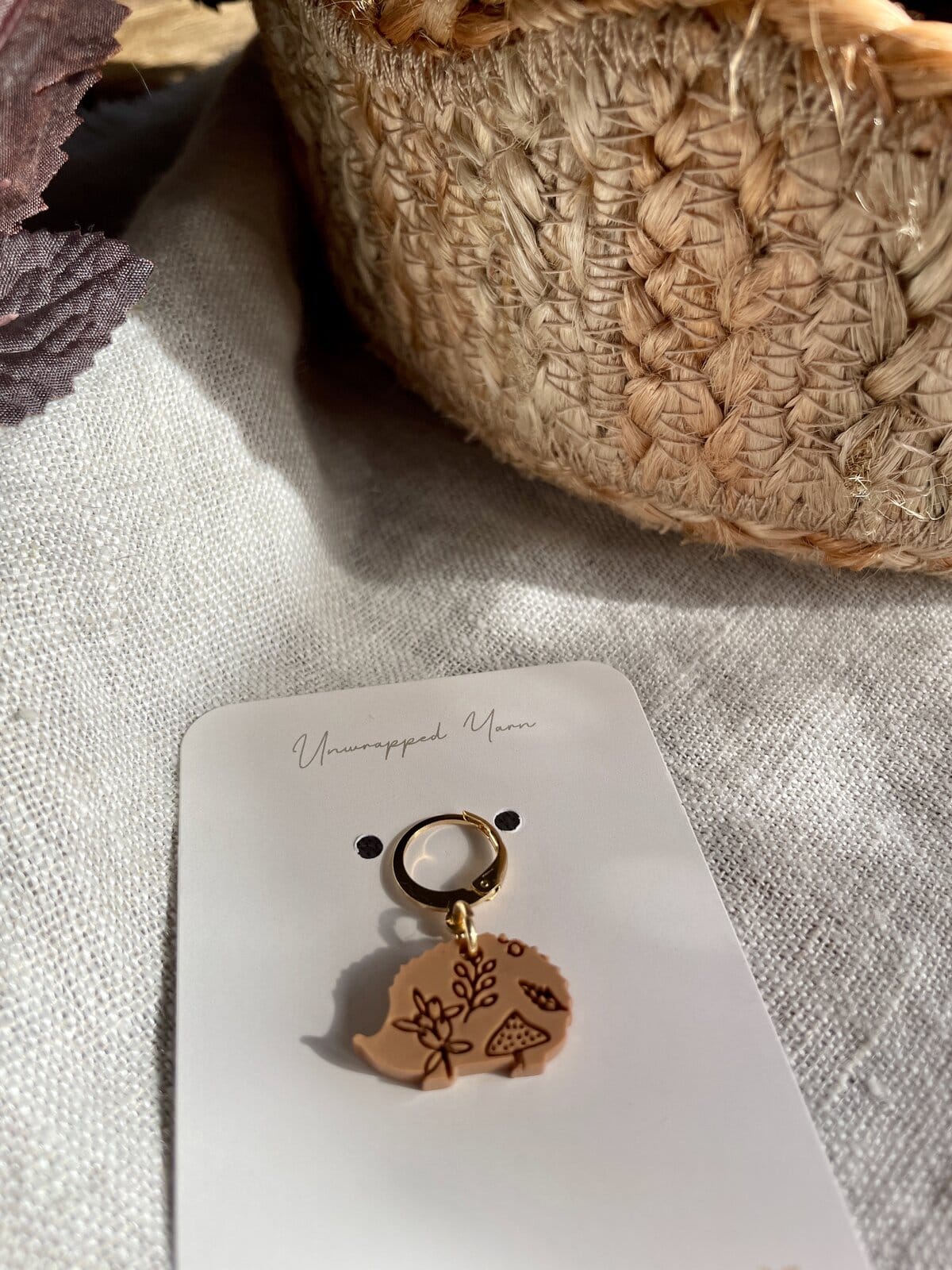 Soft beige yarn keychain with floral design for knitting and crochet projects.