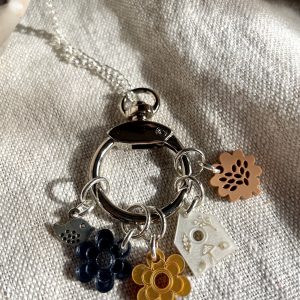 Colorful flower charm keychain with intricate details and a silver chain.