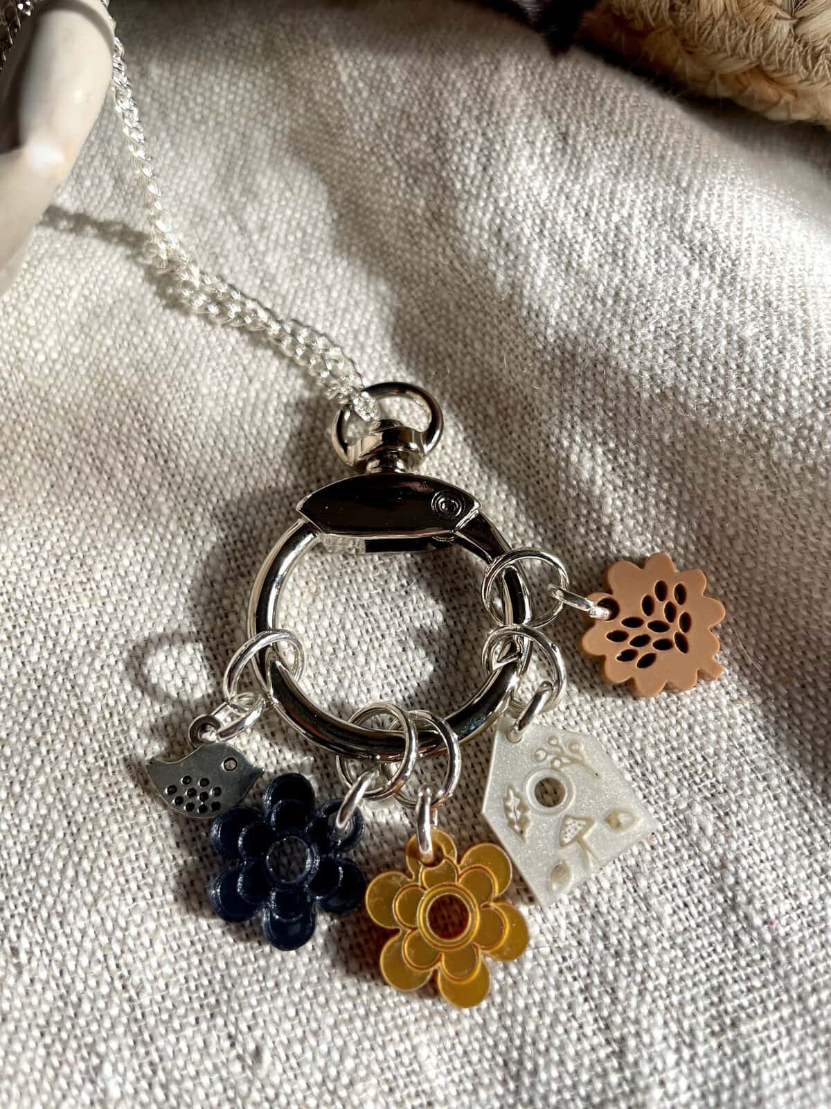 Colorful flower charm keychain with intricate details and a silver chain.