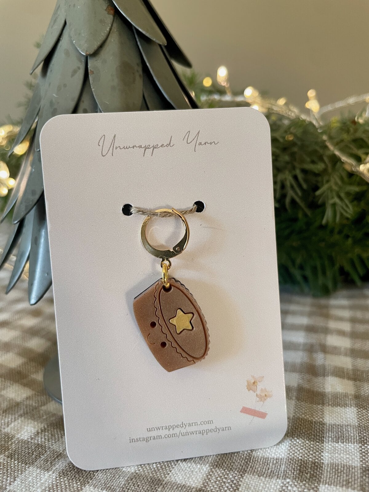 Miniature brown yarn-themed charm jewelry, perfect for knitting or crochet enthusiasts.