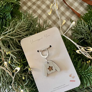 Delicate yarn-themed keychain with a cozy sweater charm, perfect for knitters and yarn lovers.