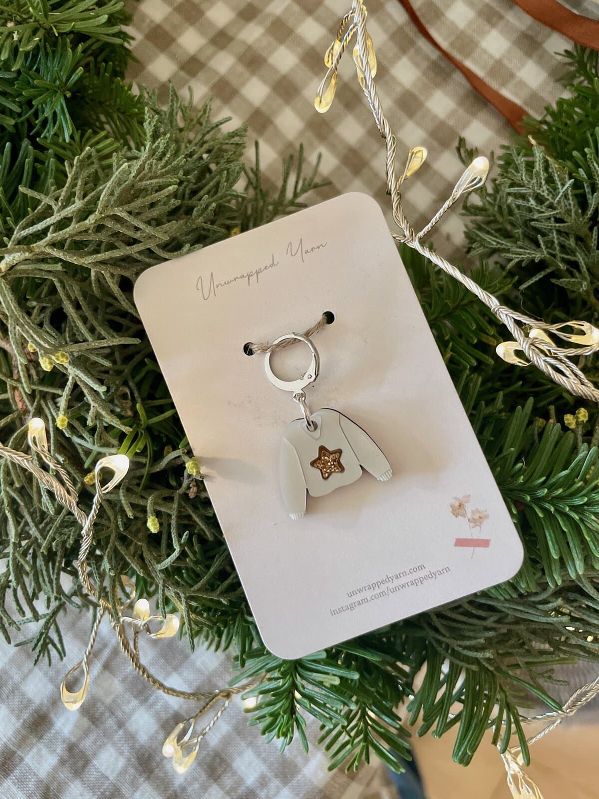 Delicate yarn-themed keychain with a cozy sweater charm, perfect for knitters and yarn lovers.