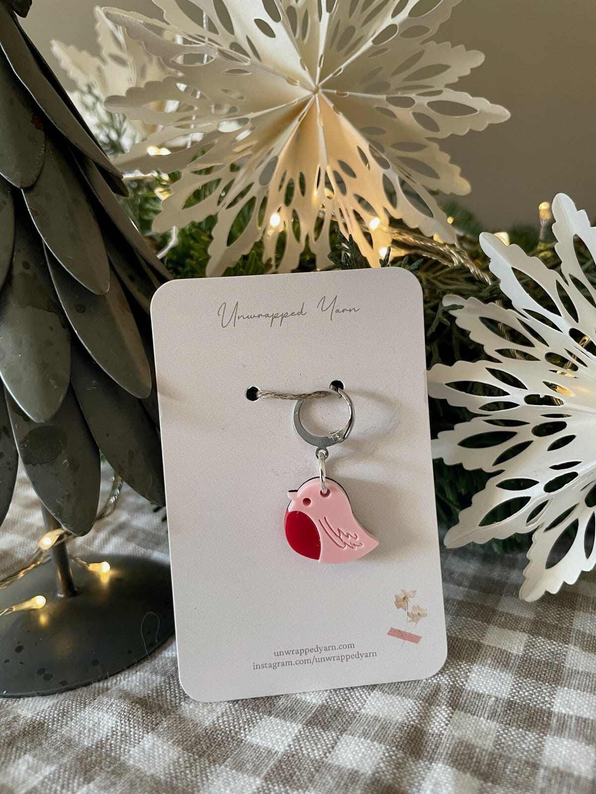 Delicate pink bird enamel keychain on gift card, perfect for jewelry and accessory lovers.