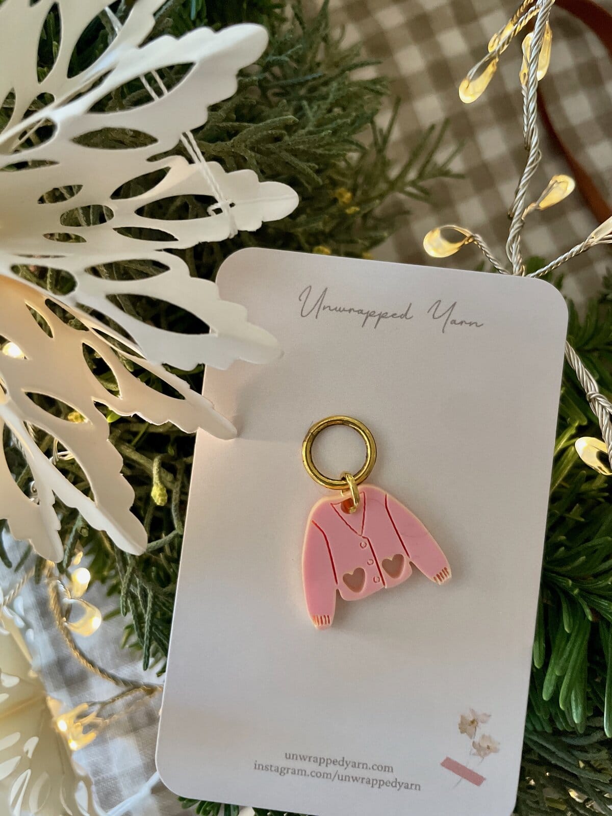 Pink sweater keychain with heart-shaped cutouts, perfect for cozy gifts or accessories.