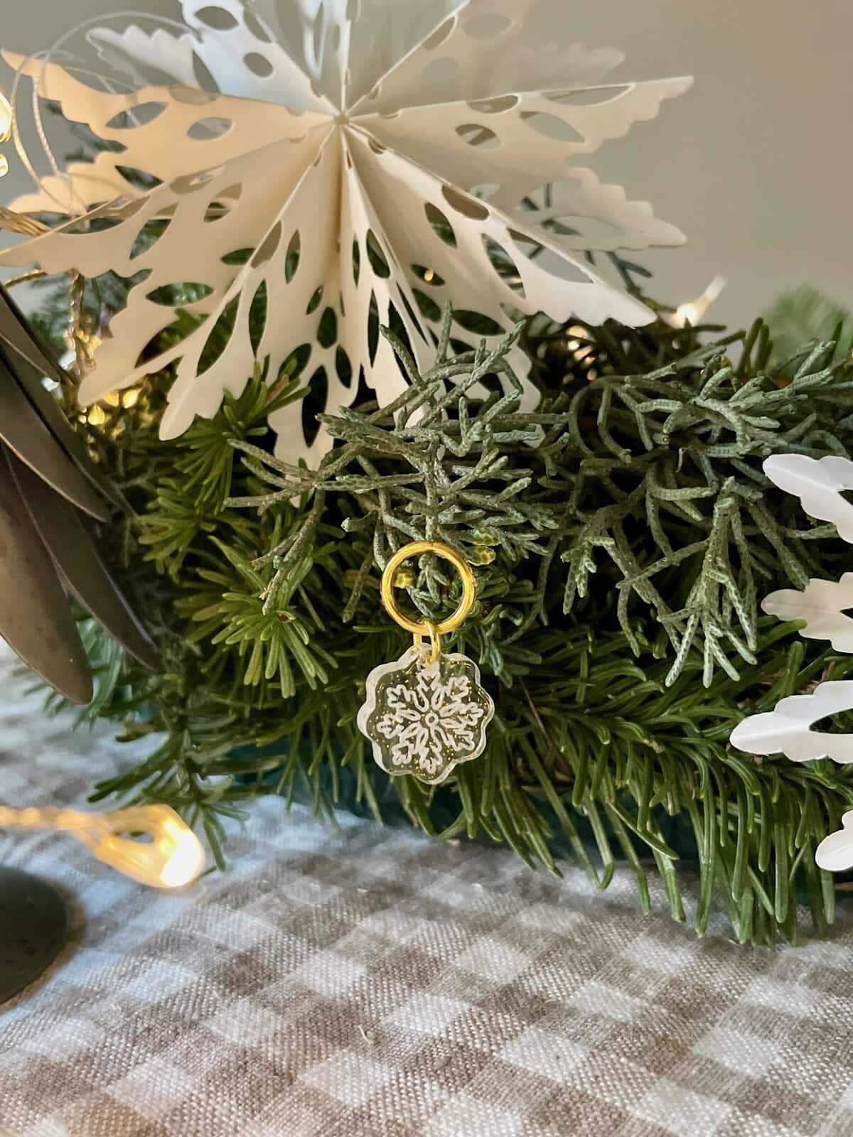 Delicate snowflake charm on a festive greenery arrangement, perfect for holiday cheer and Christmas decor.