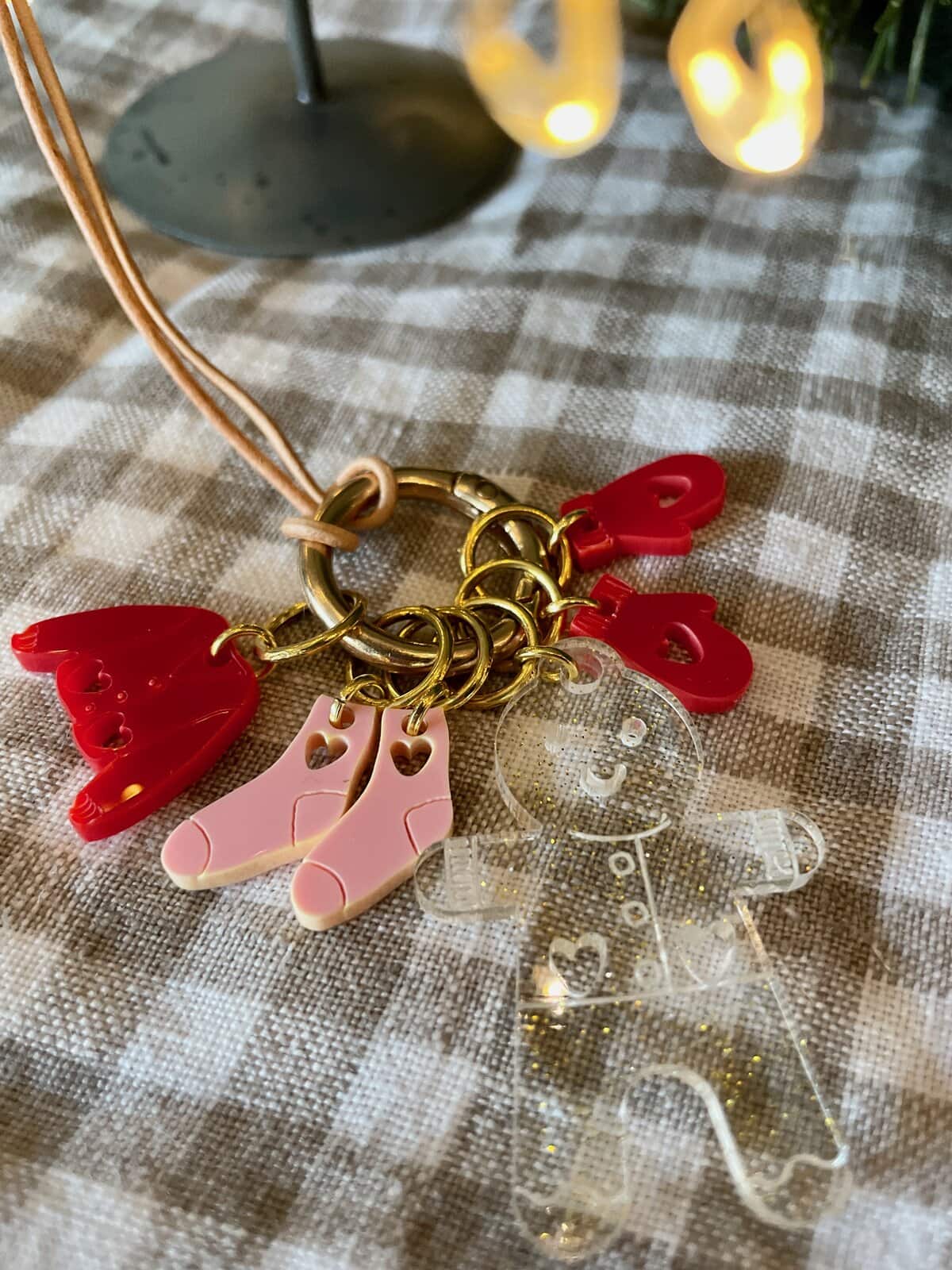 Colorful acrylic keychain charms on a gold ring with a pink strap.