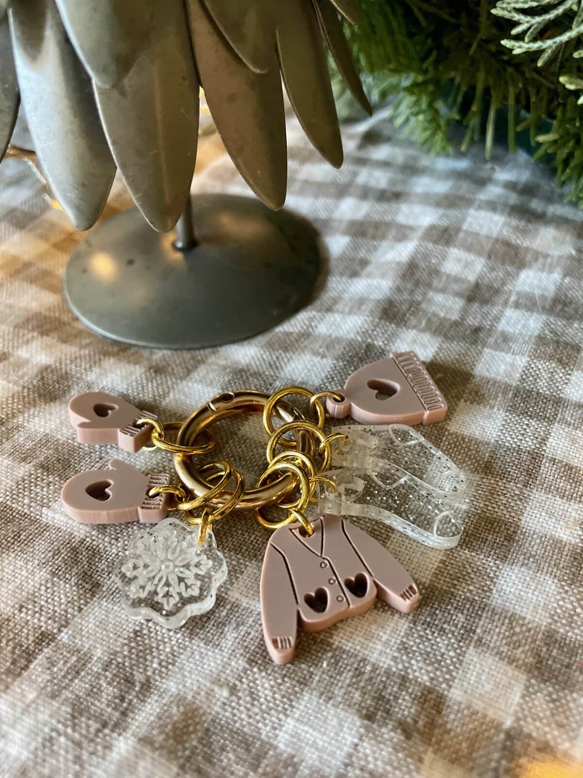 Soft pink plastic baby onesie keychain with snowflake charm and clear plastic teether, perfect for baby gifts and accessories.