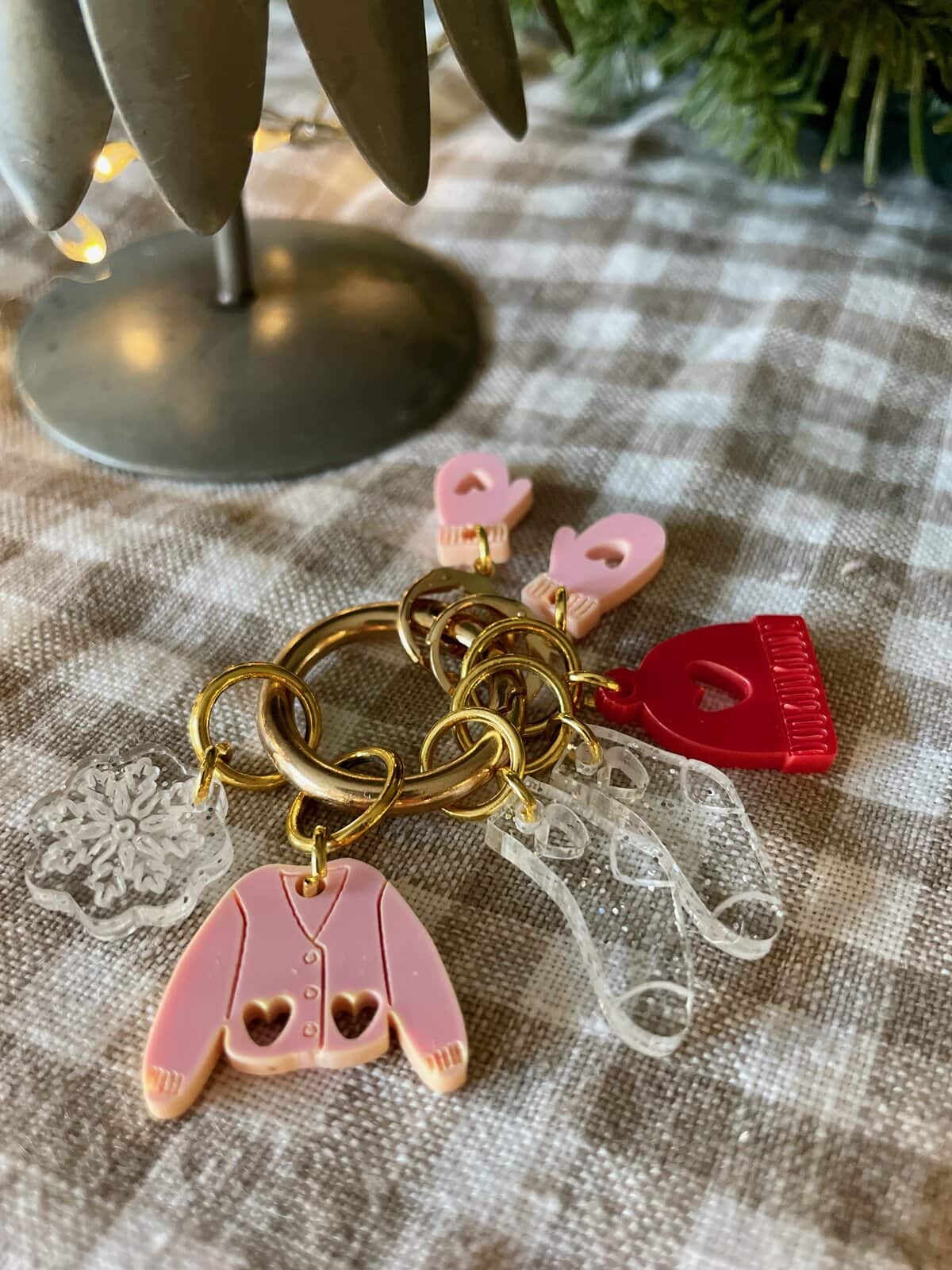 Colorful keychains with pink, red, and clear acrylic charms, on a textured fabric surface, showcasing cute, trendy accessories.