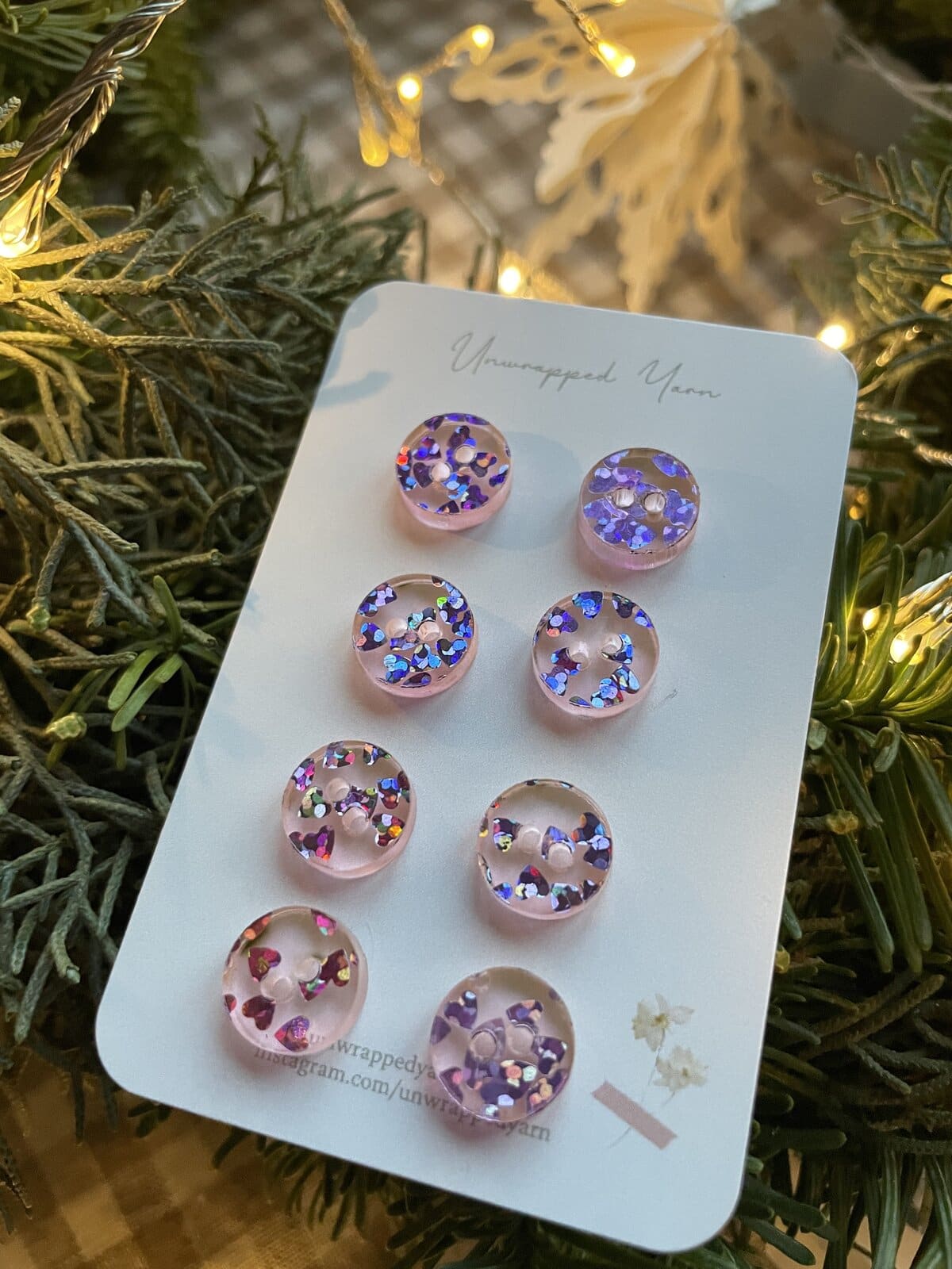 Bright pink resin buttons with multicolored glitter, perfect for DIY crafts or clothing embellishments.