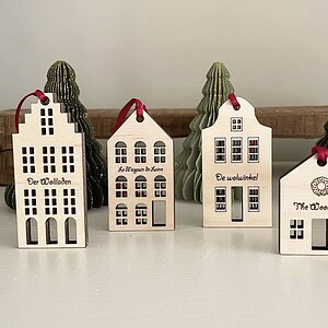 Colorful wooden house Christmas ornaments with windows and festive details, perfect for holiday decor.