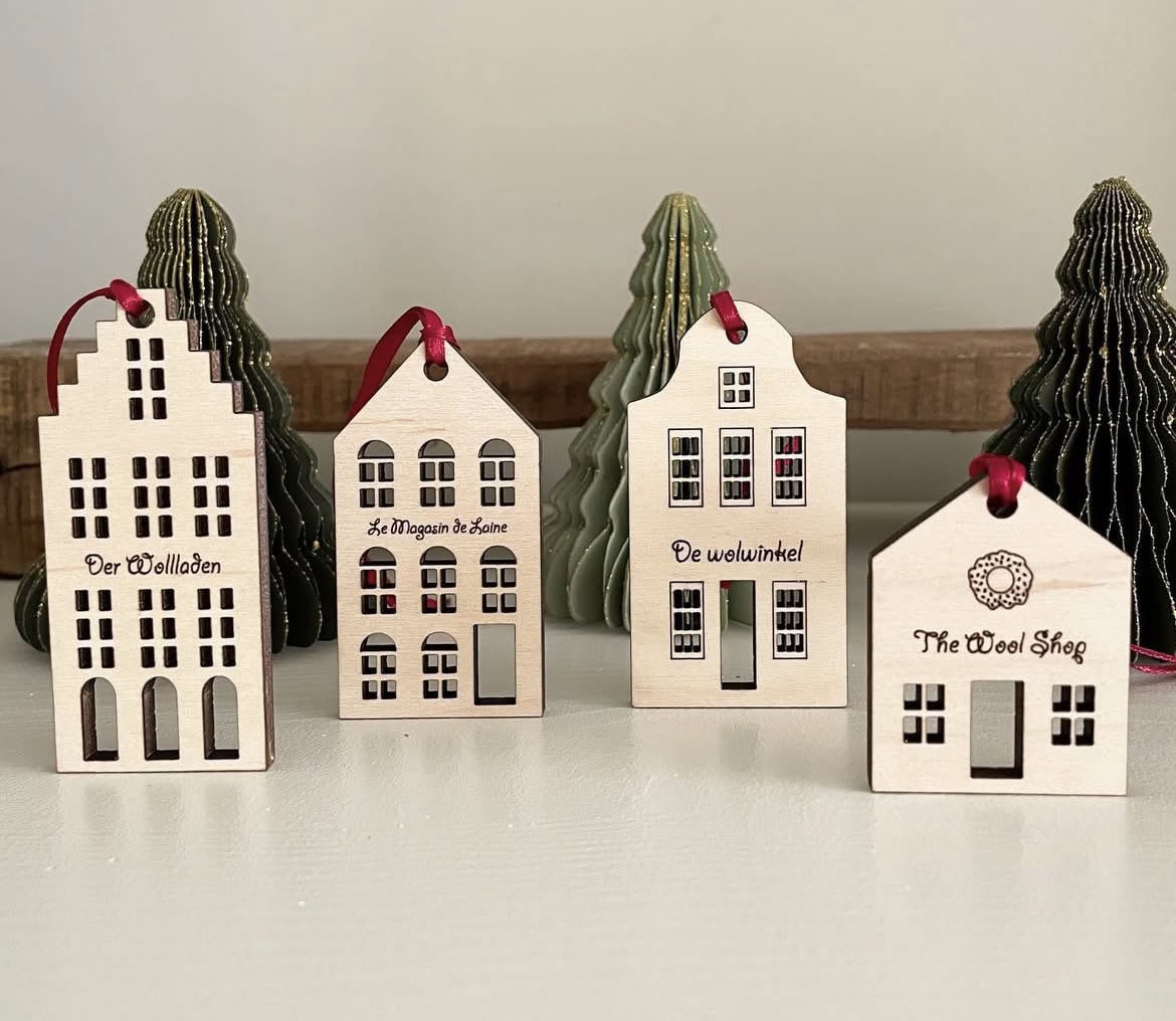 Colorful wooden house Christmas ornaments with windows and festive details, perfect for holiday decor.